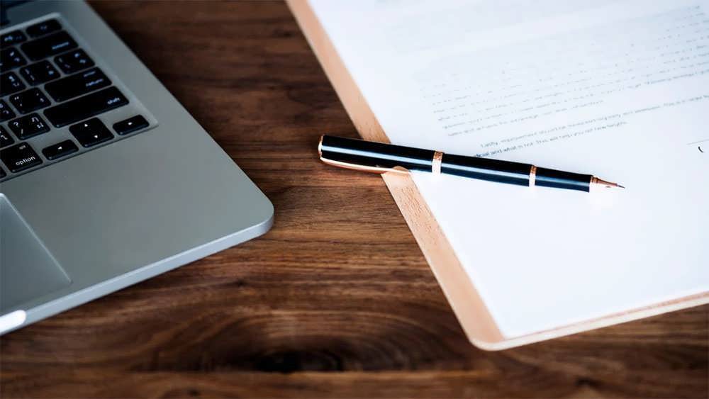 نوشتن انگیزه نامه کنار لپ تاپ