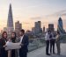معماران در حال بررسی نقشه‌ها در تراس مشرف به لندن هنگام غروب